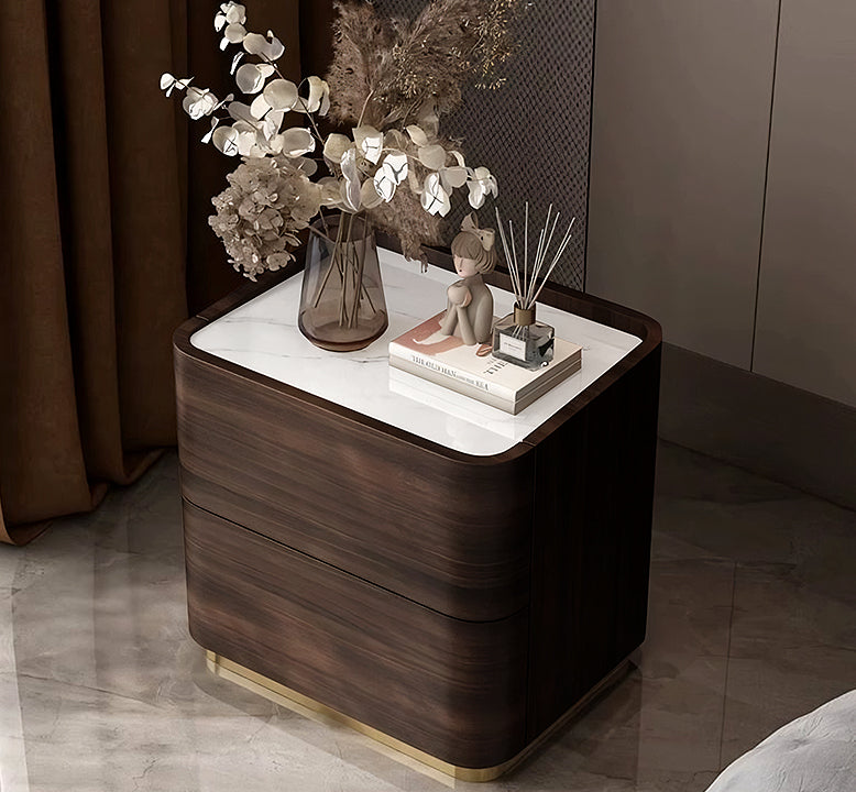 Wooden nightstand with decorative items including a vase of flowers and a figurine.