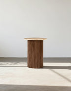 Wooden side table against a plain white wall
