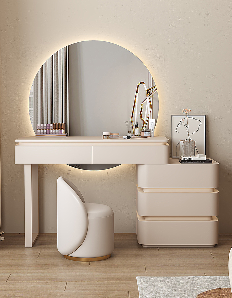 Modern vanity table with round mirror and chair in a room.