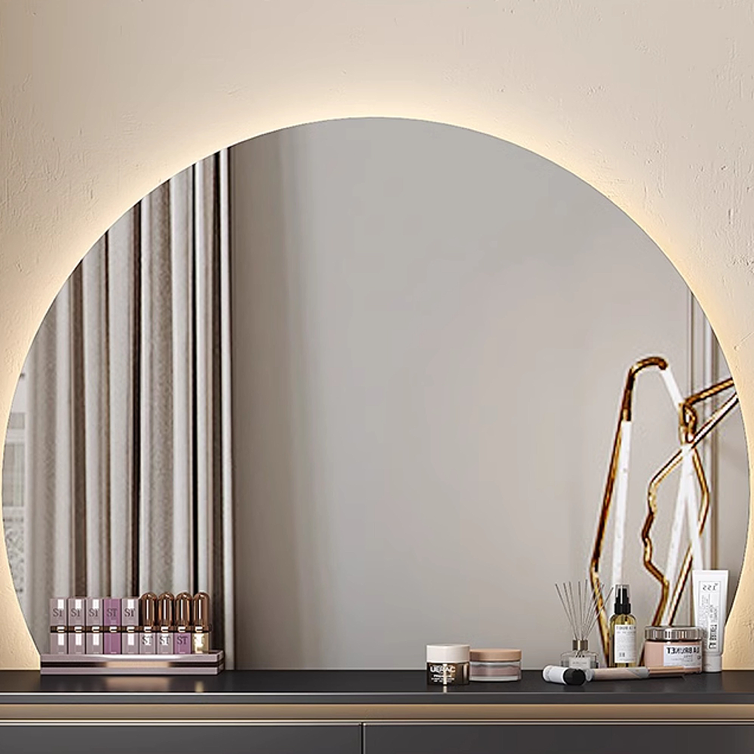 Round mirror with decorative items on a shelf against a neutral wall.