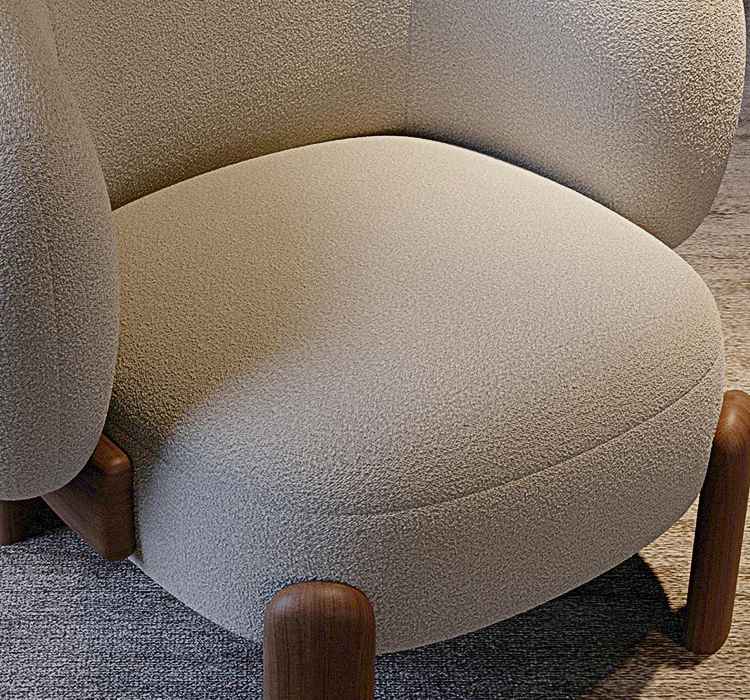Close-up of a textured armchair with wooden legs on a carpeted floor.