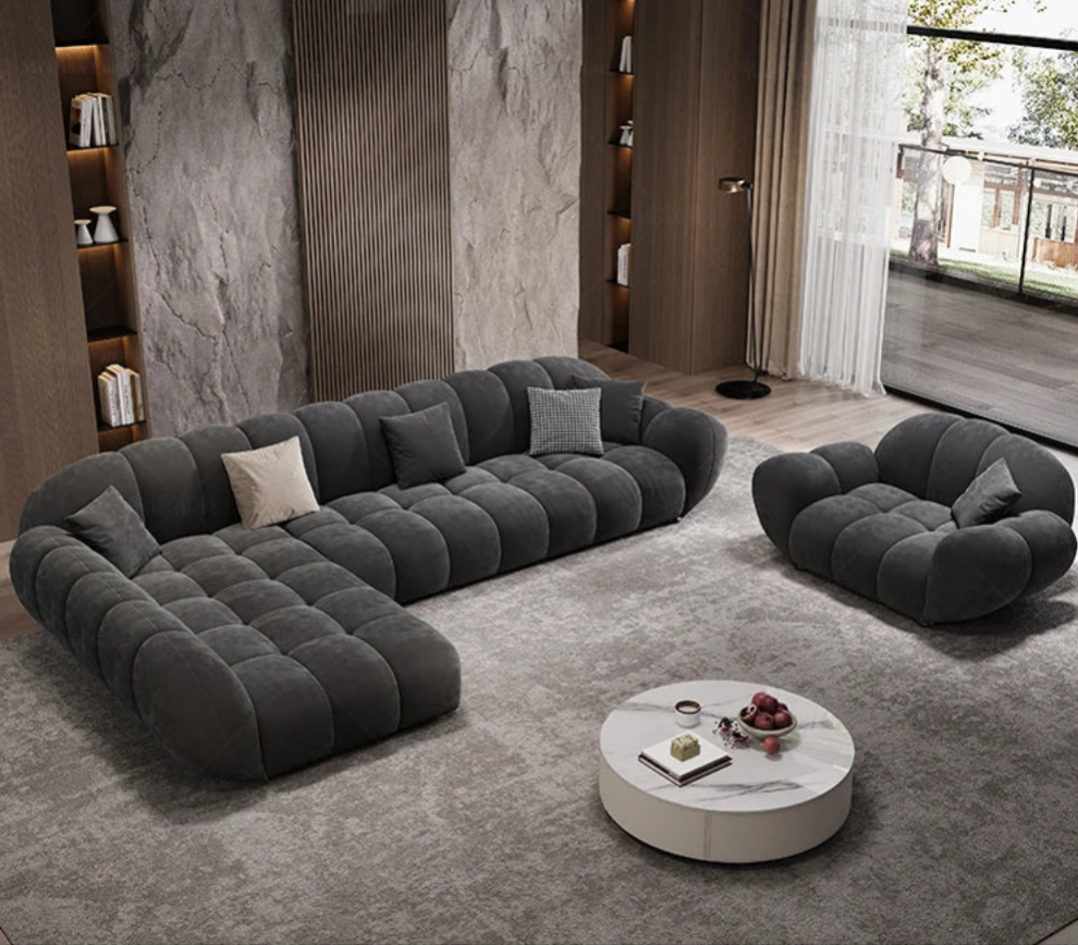 Modern living room with a gray sectional sofa and round coffee table.