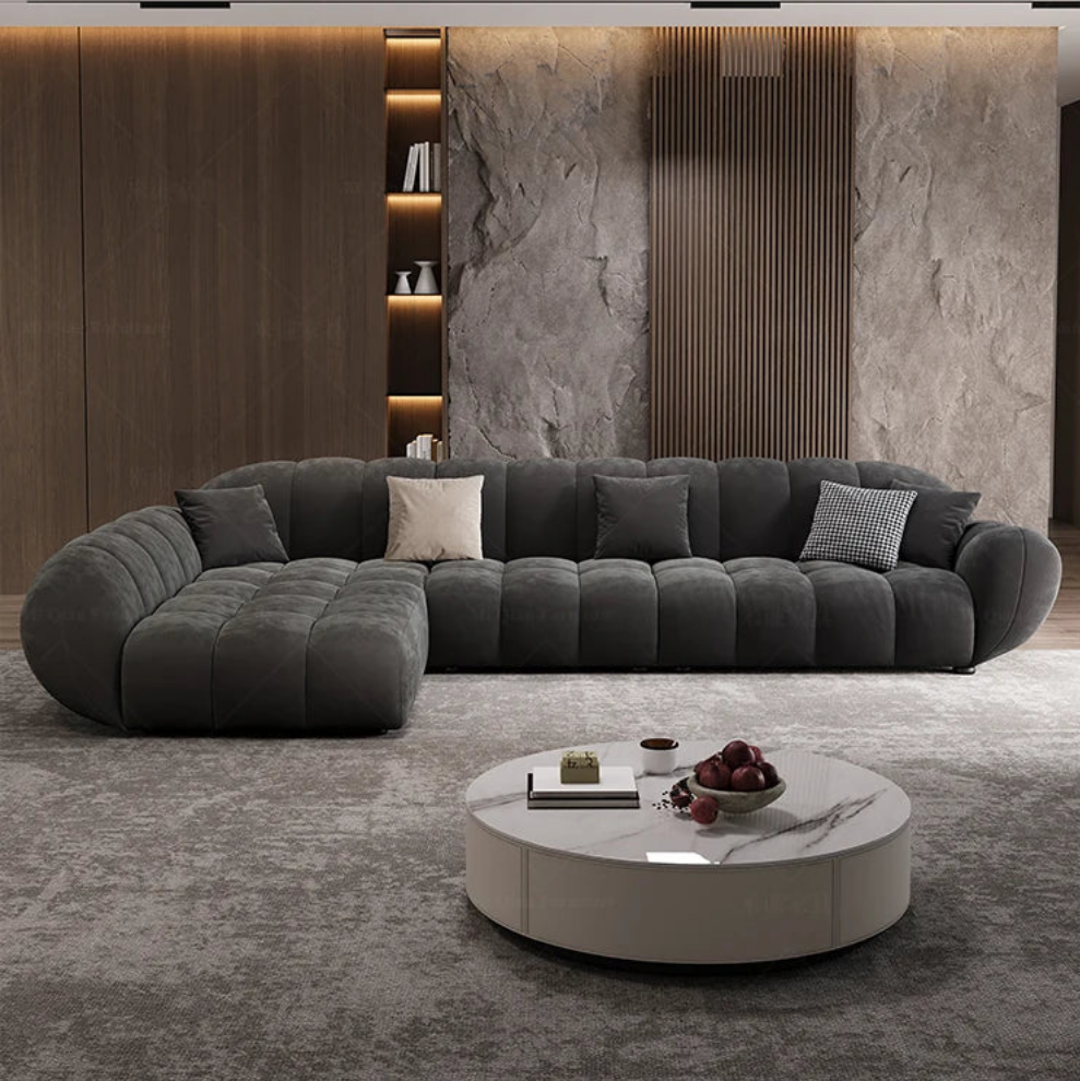 Modern living room with a gray sectional sofa and round coffee table.