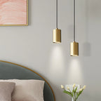 Gold pendant lights hanging above a bed with a abstract painting on the wall.