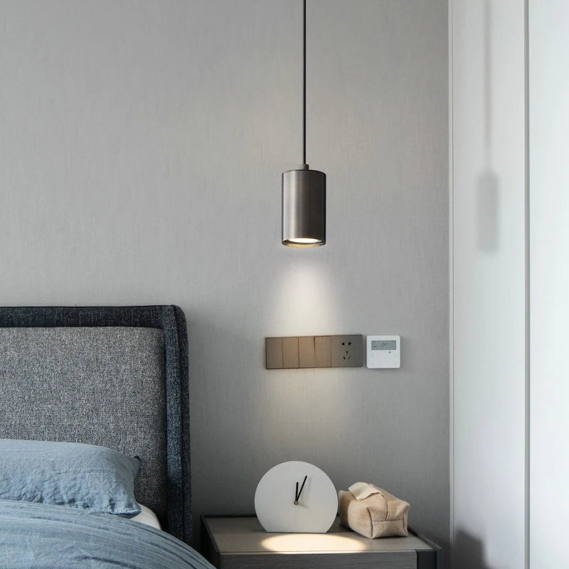 Modern bedroom with a pendant light, bed, and nightstand.
