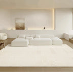 Modern living room with a white sectional sofa and a large white rug.