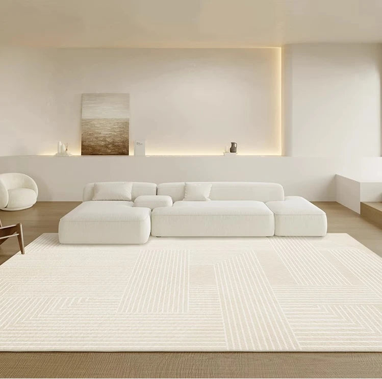 Modern living room with a white sectional sofa and a large white rug.