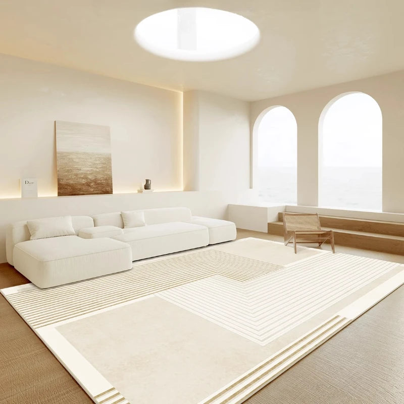 Modern living room with white sofa, rug, and large windows.