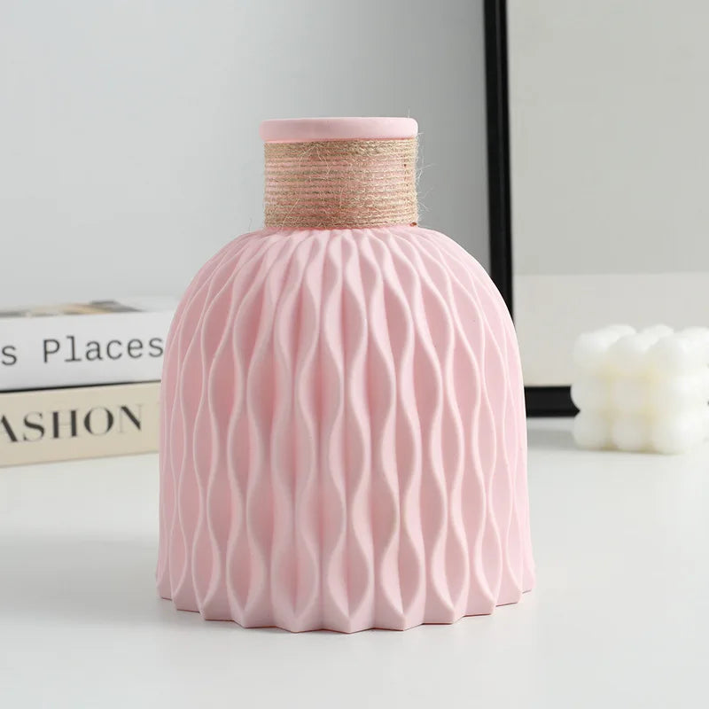 Pink textured vase with wicker top on a light surface