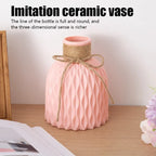 Pink ceramic vase with woven design on a wooden surface