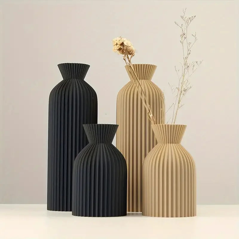 Set of four ribbed vases in black and beige on a light background