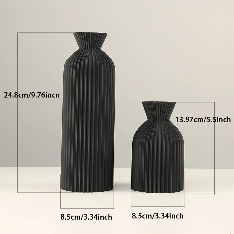 Two black ribbed vases with measurements on a light gray background