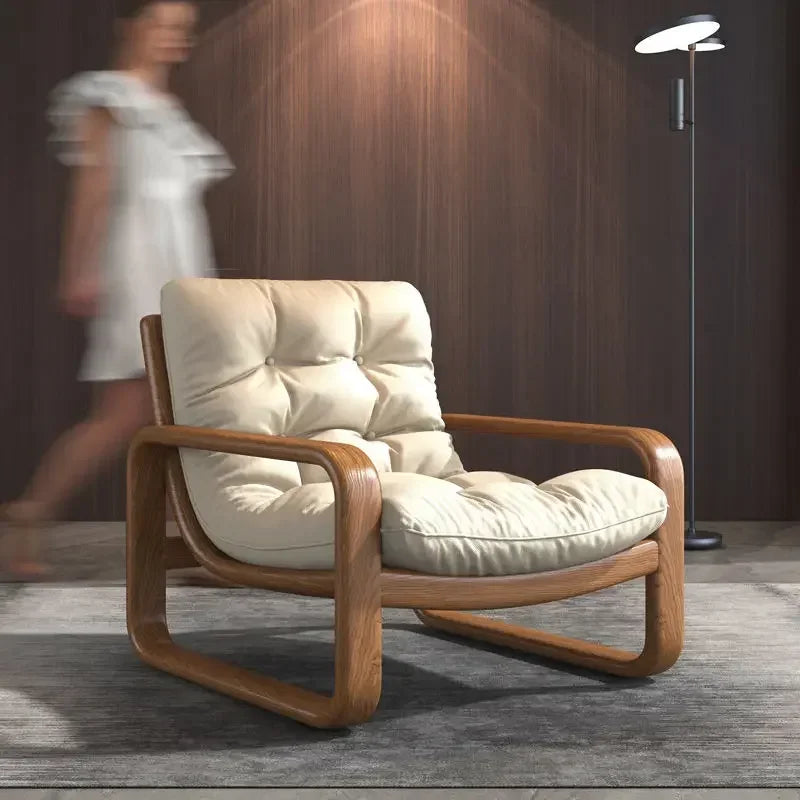 Beige armchair with wooden frame in a room with a blurred person and lamp in the background
