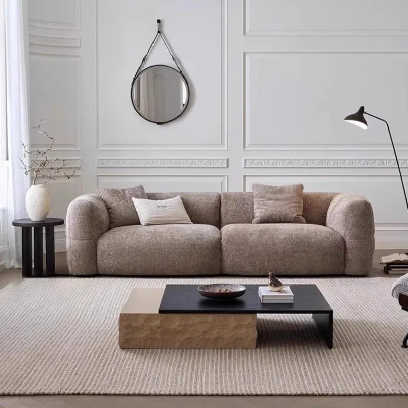 Beige sectional sofa in a living room with a coffee table and decorative items.