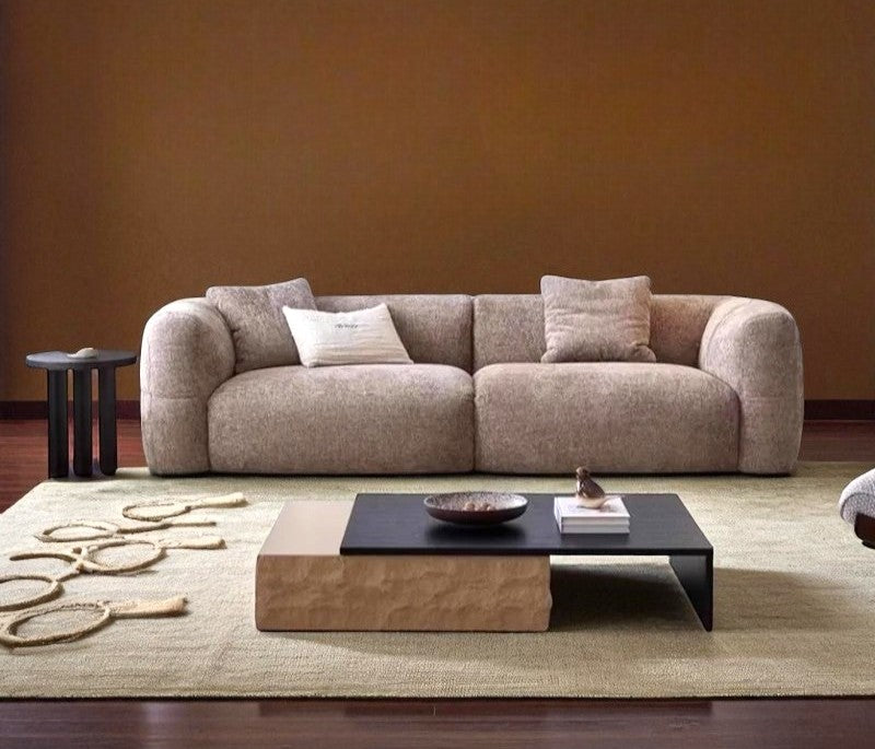 Beige sofa in a living room with a coffee table and decorative items.