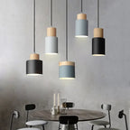 Modern pendant lights hanging above a dining table with a neutral background