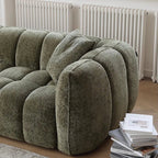 Green textured sofa in a room with white radiators.