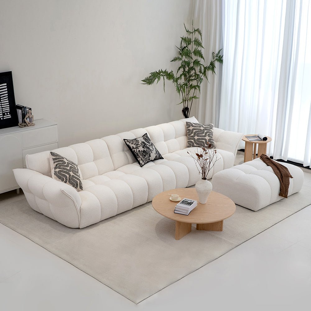 Modern living room with a white sectional sofa, coffee table, and decorative items.