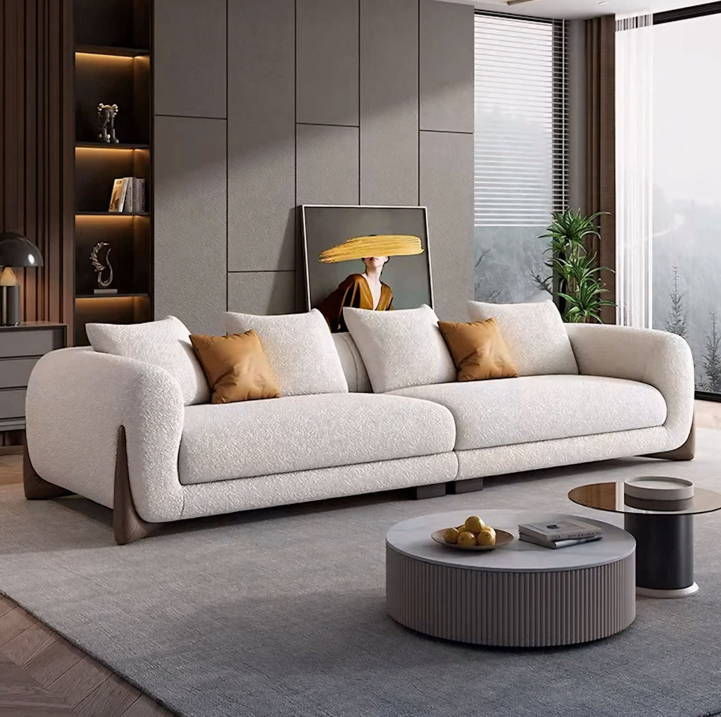 Modern living room with a beige sofa, coffee table, and decorative elements.