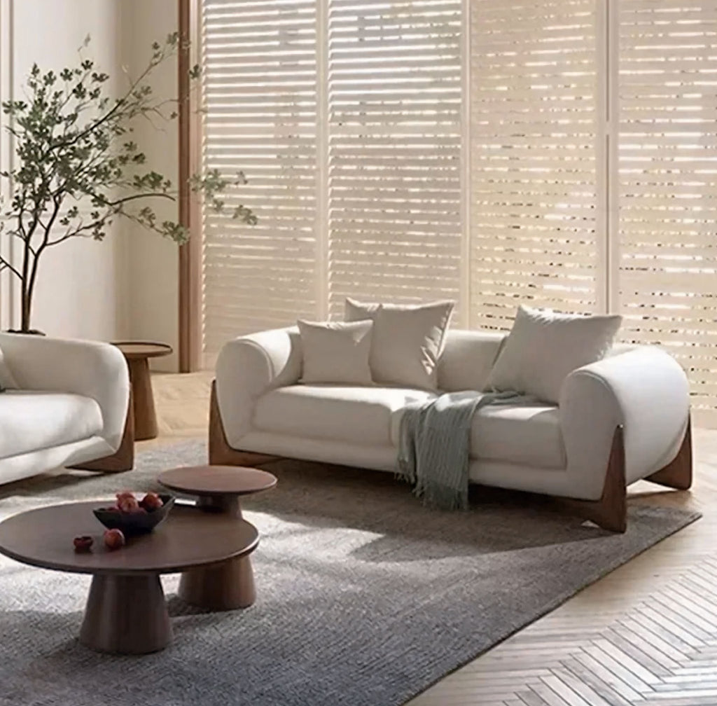 Modern living room with white sofa, armchair, and coffee tables.