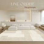 Modern living room with a white sofa, rug, and minimal decor.