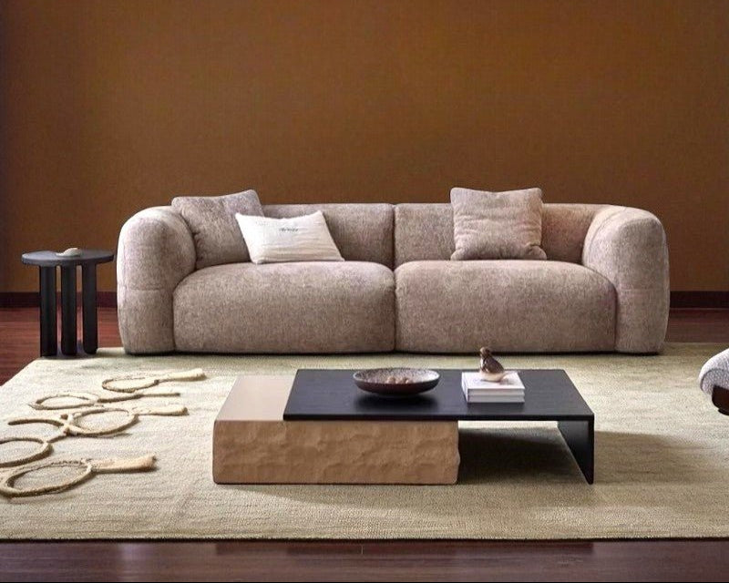 Beige sofa in a living room with a coffee table and decorative items.